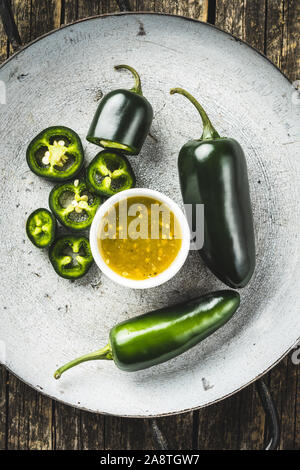 Grüne jalapeno Pfeffer und Tabasco Sauce. Ansicht von oben. Stockfoto