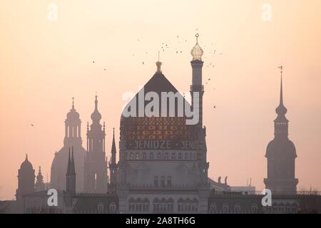 Dresden, Deutschland. 11 Nov, 2019. Die Frauenkirche (L-R), die Katholische Hofkirche, der ehemaligen Fabrikgebäude der Zigarettenfabrik Yenidze und Turm der Burg als Silhouette bei Sonnenaufgang. Credit: Sebastian Kahnert/dpa-Zentralbild/dpa/Alamy leben Nachrichten Stockfoto