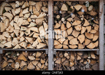 Protokolle von Brennholz im Wald stack Lagerschuppen im Winter bei Schneefall im Freien Stockfoto