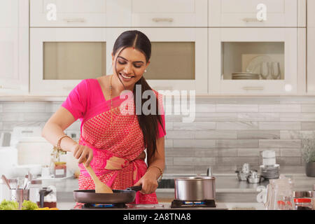 Frau Saree Kochen in der Küche Stockfoto