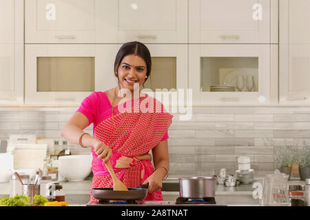 Frau Saree Kochen in der Küche Stockfoto