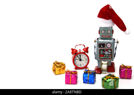 Retro Roboter in einem neuen Jahren hat ist bereit, Weihnachten und das neue Jahr zu erfüllen. Neben dem Roboter sind ein roter Wecker, die fast Mitternacht, und viele Geschenke. C Stockfoto