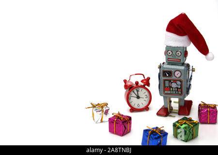 Retro Roboter in einem neuen Jahren hat ist bereit, Weihnachten und das neue Jahr zu erfüllen. Neben dem Roboter sind ein roter Wecker, die fast Mitternacht, und viele Geschenke. C Stockfoto