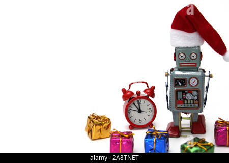 Retro Roboter in einem neuen Jahren hat ist bereit, Weihnachten und das neue Jahr zu erfüllen. Neben dem Roboter sind ein roter Wecker, die fast Mitternacht, und viele Geschenke. C Stockfoto