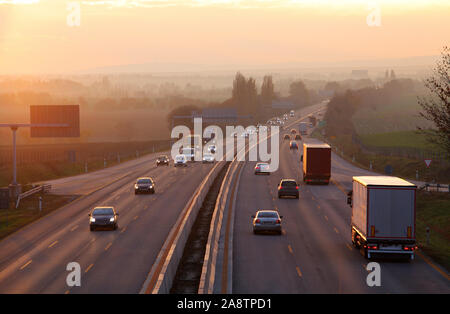 Autos auf Autobahn Straße bei Sonnenuntergang Stockfoto