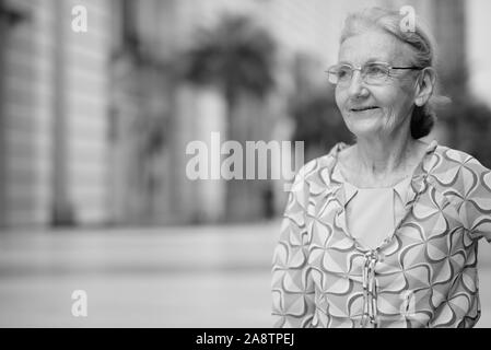 Schöne senior touristische Frau entspannende rund um die Stadt in Schwarz und Weiß Stockfoto
