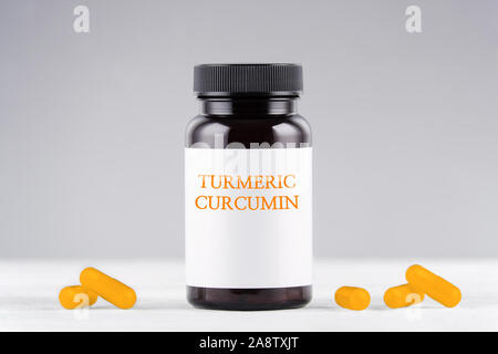 Nahrungsergänzung turmeric Curcumin Flasche und Kapseln auf Grau Stockfoto