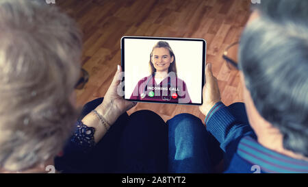 Senior Paar zu Hause halten digitale Tablet während der Videokonferenz mit Hausarzt - telehealth Konzept Stockfoto