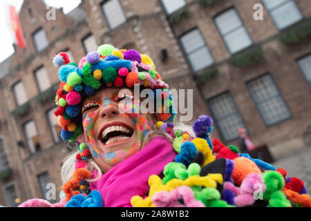 Düsseldorf, Deutschland. 11 Nov, 2019. Eine verschleierte Narr lacht vor dem Rathaus. In Deutschlands Karnevalshochburgen Die närrischen Zeit beginnt um elf Uhr elf. Credit: Federico Gambarini/dpa/Alamy leben Nachrichten Stockfoto