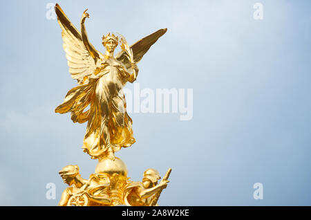 Nahaufnahme der goldenen, geflügelten Siegesstatue, die auf dem öffentlichen Victoria Memorial steht, das im Jahr 1924 unter dem stimmungsvollen Himmel in London, Großbritannien, fertiggestellt wurde Stockfoto