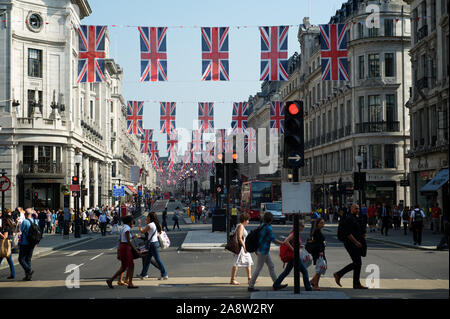 LONDON - 24. MAI 2012: britische Union Jack Fahnen schmücken eine vielbefahrene Kreuzung voller Fußgänger in der Regent Street Shopping District. Stockfoto