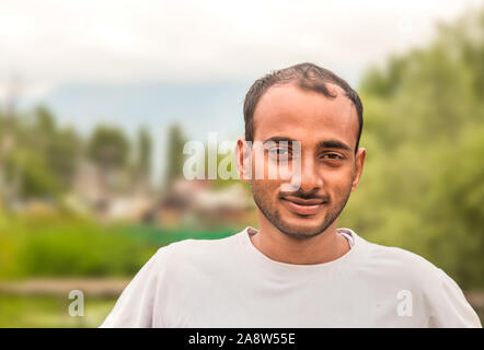 Closeup headshot Porträt, glücklich, gut aussehender Inder, entspannende außerhalb der Natur Szene während der sonnigen Tag Stockfoto