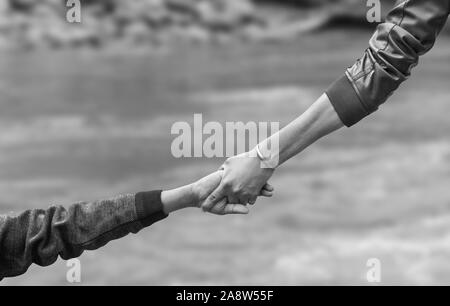 Helfende Hand für Heil ausgestreckt. Starken Halt. Jedes Paar wandern helfen Sie anderen in den Bergen Fluss. Stockfoto