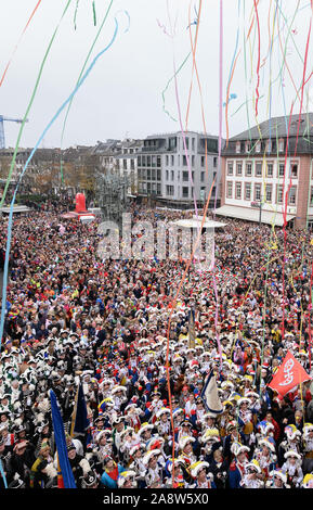 Mainz, Deutschland. 11 Nov, 2019. Zahlreiche Menschen stehen auf dem Schillerplatz während der Lesung des "närrischen Grundgesetze'. Traditionell jedes Jahr die "närrischen Grundgesetze" mit ihren elf Artikeln für die Narren Freiheit sind am 11.11. um 11:11 Uhr in Mainz. Credit: Silas Stein/dpa/Alamy leben Nachrichten Stockfoto