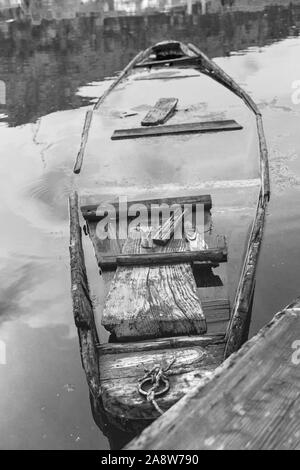 Alte Holz- Boot, Kanu in einem See. Ein rot orange Holz- Boot sitzt auf einem See, Auffüllen mit Wasser Stockfoto