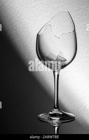 Studio Nahaufnahme einer zerbrochenen Glas Wein mit zerbrochenen Fragmenten vor diagonale Hintergrund. Stockfoto