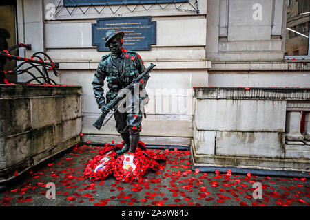 Eine Statue von Feldmarschall Earl Haig von Bemersyde ist in poppy Blüten bedeckt, wie Käufer im Stadtzentrum von Liverpool beobachten, eine Stille, um zu Armistice Day, dem Jahrestag des Endes des Ersten Weltkriegs markieren. Stockfoto