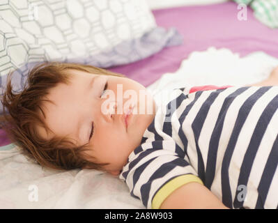 Sleeping Baby im Bett der Eltern. 0-1 Jahre altes Baby. Porträt eines Neugeborenen im Bett der Eltern. Das Baby tagsüber schlafen. Sorgloses Leben von Kindern. Guter Schlaf Stockfoto