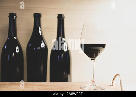 Immer noch leben, drei schwarze Flaschen und roten wineglass Stockfoto