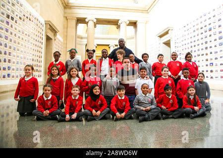 London, Großbritannien. 11 Nov, 2019. Schule Kinder von Tyssen Community School in Hackney stellt für Fotographie mit Turner Prize-winning Artist und der Oscar-prämierte Regisseur Steve McQueen während der Vorschau der teve McQueen Jahr 3"-Ausstellung in der Tate Britain. Eine Installation von über 3.000 Klasse Fotografien an den Wänden der Tate BritainÕs Duveen Galerien, die mehr als 70.000 Jahre 3 Schülerinnen und Schüler aus LondonÕs Grundschulen. Die Ausstellung wird am 12. November bis 3. Mai 2020. Credit: Dinendra Haria/Alamy leben Nachrichten Stockfoto