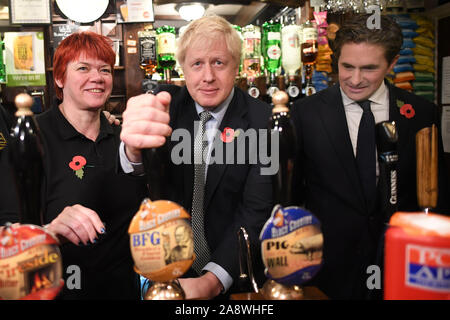 Premierminister Boris Johnson, zieht ein Pint beobachtet von Verteidigungsminister Johnny Mercer (rechts) trifft er sich mit militärischen Veteranen an der Lych Gate Taverne in Wolverhampton. Stockfoto