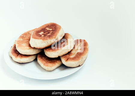 Gebratene Kuchen mit Kartoffeln und Bohnen auf weißem Hintergrund Stockfoto