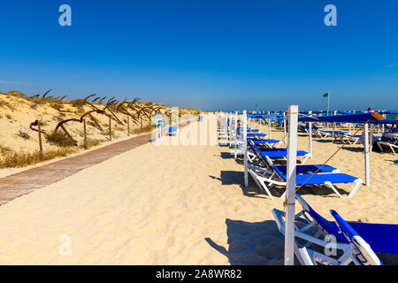 Sonnenliegen am schönen Sandstrand Algarve Barril, Santa Luzia Algarve, Portugal. Stockfoto