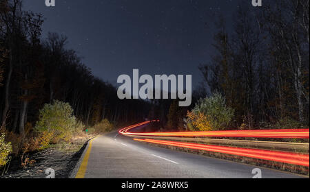 Spuren der Autoscheinwerfer in einer Nacht Straße Stockfoto