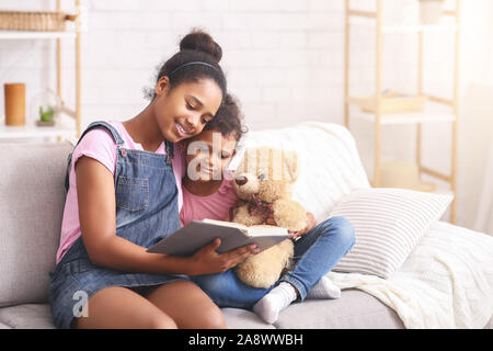 Zwei afrikanischen Schwestern lesen Märchen zu Hause Stockfoto