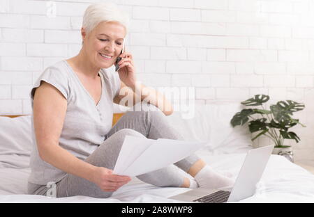 Zuversichtlich Senior Business Lady über Verträge und Dokumente per Telefon Stockfoto