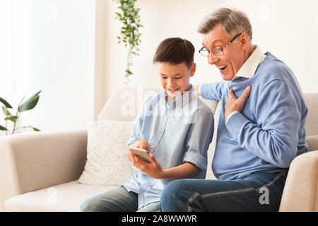 Enkel Lehre Opa auf dem Telefon sitzen auf einem Sofa zu Hause Stockfoto