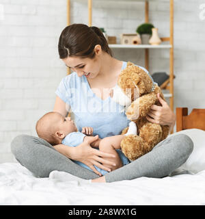 Hübsche Mama, weichen Teddybären zu Ihrem neugeborenen Baby Stockfoto