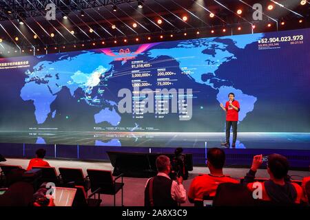 (191111) - Peking, November 11, 2019 (Xinhua) - ein Mitarbeiter der Alibaba Group spricht vor einem riesigen Bildschirm angezeigt, der die realen Verkaufsdaten der Tmall auf der 2019 Singles Tag am Media Center in der Alibaba Group Xixi Park, in Hangzhou, Provinz Zhejiang, Nov. 11, 2019. (Xinhua / Yin Xiaosheng) Stockfoto