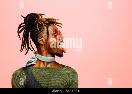 Studio Profil Portrait von modebewussten jungen Mann mit Sonnenbrille und Zunge Stockfoto