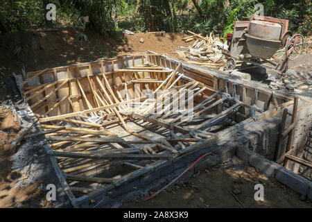 Den Boden versenkten Pool im Prozess der Konstruktion. Mauerwerk Schalung verstärkt mit Bambus-Amtsleitungen. Ausgegraben Ton stapelten sich um ein tiefes Loch. Stockfoto