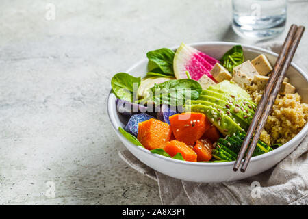 Quinoa Salat mit Tofu, Avocado und Gemüse in einer weißen Schüssel. Veganes Frühstück. Buddha Schüssel mit einer gesunden vegetarischen Salat. Stockfoto