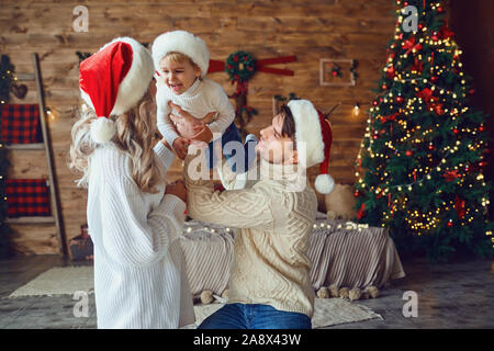 Eltern spielen mit ihren Sohn im Zimmer zu Weihnachten. Stockfoto