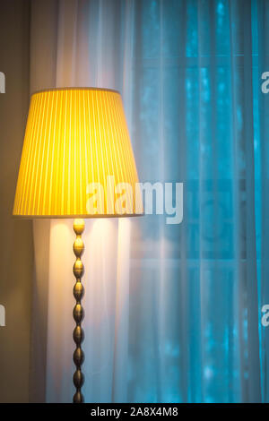 Ein gemütlicher Ort, um ein Buch zu Hause zu lesen - eine Lampe am Fenster Stockfoto