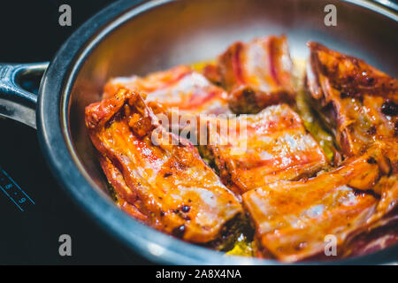 Schweinerippchen in pikanter Tomatensauce. Stockfoto