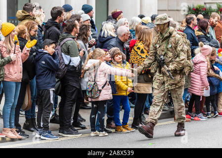 Britische Armee Soldat an des Herrn Bürgermeister Show Parade in der Stadt London, UK High fiveing, Umgang mit den Kindern. Die Interaktion mit Jugendlichen Stockfoto