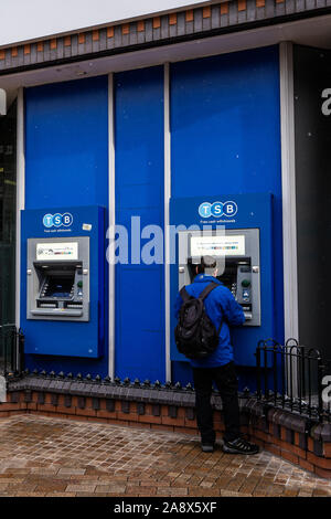 Ein Mann mit einem Geldautomaten, ATM in TSB Bank in der Hauptstraße der Stadt, ein Geldautomat, Geld abheben Stockfoto