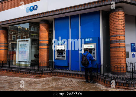 Ein Mann mit einem Geldautomaten, ATM in TSB Bank in der Hauptstraße der Stadt, ein Geldautomat, Geld abheben Stockfoto