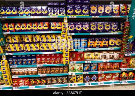 Eine junge schöne Schule Jungen mit ADHS, Autismus, Asperger-syndrom aussieht, durchsucht, wirft einen Blick auf einige Ostereier im lokalen Supermarkt Tesco extra speichern Stockfoto