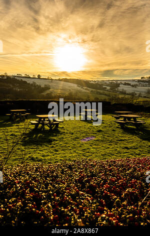 Sonnenuntergang über einige Picknicktische in der glorreichen Derbyshire Peak District National Park, Leere Tabellen auf einem eisigen kalten Januar Abend bei Sonnenuntergang Stockfoto