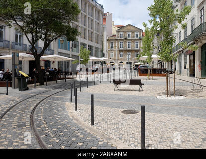 Touristen und Einheimische genießen Cafés im Freien auf einem öffentlichen Platz in der Altstadt von Lissabon, Portugal. Stockfoto