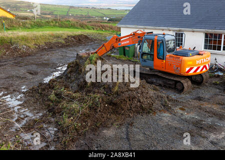 Aushub Boden an der Rückseite des privaten Haus mit Bulldozer, den Boden für die Entwässerung zu Ebene Stockfoto