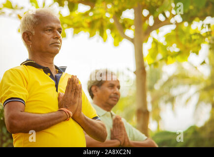 Selektiver Fokus auf Händen ältere Männer üben einfache Yoga - Fitness, Sport, Yoga und gesunden Lebensstil Konzept - zwei ältere Männer mit Namaste Haltung Stockfoto