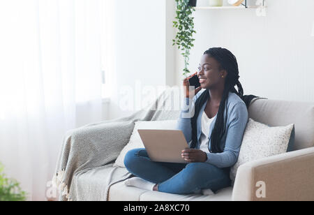 Frau am Telefon sprechen und mit Laptop, Suche Job online Stockfoto