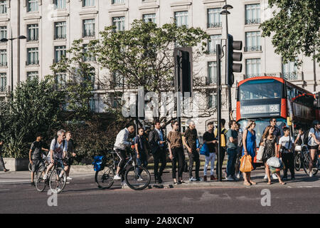 London, Großbritannien - 18 Juli 2019: Fußgänger und Radfahrer auf der Straße neben dem Marble Arch, London, ein Gebiet Namen, die nach dem 9. Jahrhundert weiß marbl zu überqueren Stockfoto