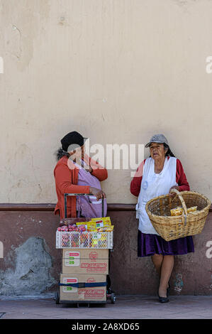 Zwei Frauen sprechen und Verkauf von Snacks auf einer Straße in Cuenca, Ecuador Stockfoto